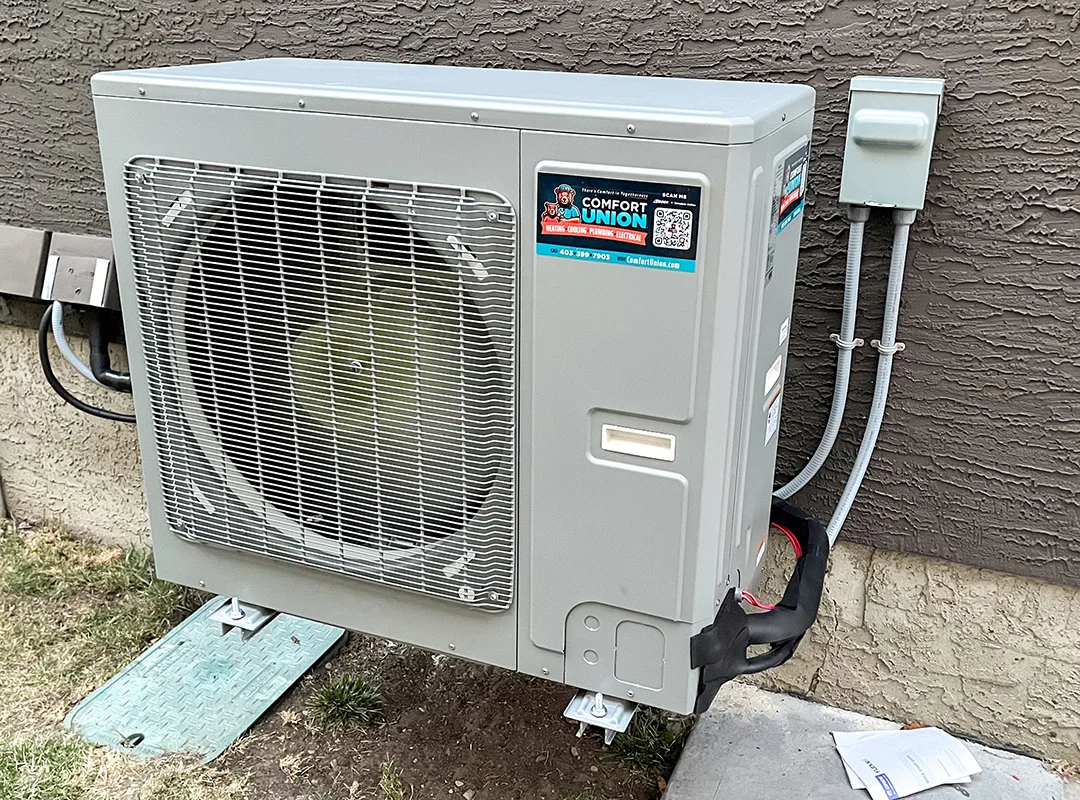 High-efficiency heat pump unit set up by Comfort Union next to a home exterior